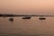 View of small, wooden fishing boats, Aegean sea and landscape at sunset captured in Ayvalik area of Turkey in summer.