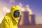 View of smoking coal power plant and men in protective hazmat suit