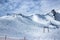 View of the snow-covered mountain range. Ski tracks on the mountainside and chairlift