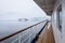 View of snow covered shoreline from outside deck of cruise ship, Antarctica