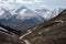 view of snowy peaks with rugged terrain from winding mountain road