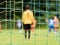 View through soccer gate net. The goalkeeper slowly backs up during the opponents attack. Abstract view