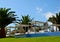 View of some beds sunloungers and palm trees on a green grass in a beach club of Tenerife,Canary Islands,Spain.