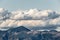 A view of some mountains top with some big, close clouds above t