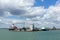 View of Southampton Docks with big cruise ship and cargo vessel on calm summer day with fine weather blue sky and white clouds