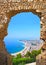 View of Spanish beach through stone door in Blanes, Costa Brava