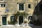 View of a square in the historical center of the city of Corfu in Greece some white plastic chairs under a pergola in front of an