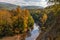 View from steep bank of Afips river at sunset. Scenic sunny golden autumn landscape of Caucasus Mountain forest at Seversky