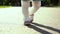 View of stepping feet of toddler girl walking in sunny park with parents