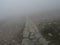 View of stone footpath of mountain trail in a dangerous thick fog with almost zero visibility