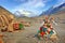 View of stone formation covered by colorful praying flags near the RongPu Monastery, against a blue sky above Mount