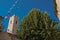 View of stone steeple tower next to church and tree in Vence.