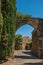 View of stone wall and arch under sunny blue sky at Les Arcs-sur-Argens.