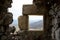 A view of the stony window of the old castle in the background is a village many miles away