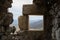 A view of the stony window of the old castle in the background is a village many miles away