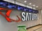 View on store front with logo lettering of saturn electronics chain in shopping mall focus on center of left red logo