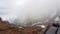 View of the strap backpack in the mountains. Clouds drift past. Snow is visible on the mountain slopes