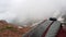 View of the strap backpack in the mountains. Clouds drift past. Snow is visible on the mountain slopes