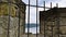 View from Stronghold through Bars at Lake and Mountains with Clouds on Sky