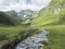 View on Stubaital Valley and alpine meadow with river stream and grazing cows, Alpine landscape of Tirol Alps, Austria