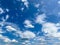 View into summer sky with fluffy cumulus and cirrus clouds