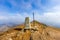 A view of the summit trig point of a Scottish mountain Ben Vorlich with eroded rocky soil under a majestic blue sky and altitude