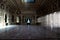 View of sunlight entering from the window arches to an empty medieval hall