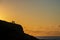 View of sunset on cliff with silhouettes of people, next to the sea, horizontally,