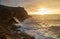 View of the sunset and the old lighthouse on a rock with a fortress on the coast of the Atlantic Ocean in the city of