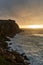 View of the sunset and the old lighthouse on a rock with a fortress on the coast of the Atlantic Ocean in the city of