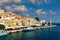 View on Symi Simi island harbor port, classical ship yachts, houses on island hills, Aegean Sea bay. Greece islands holidays