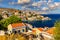 View on Symi Simi island harbor port, classical ship yachts, houses on island hills, Aegean Sea bay. Greece islands holidays