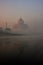 View of Taj Mahal reflected in Yamuna river with early morning f