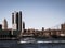 View of tall buildings in New York City with a yacht travelling across the river