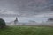 View on a Terryland castle by River Corrib in Galway city Ireland. Calm cool morning with fog and soft pastel cloudy sky. Calm and