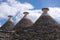 View of three conical dry stone roofs of a traditional trullo dry stone houses in Alberobello in Puglia Italy.