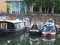 A view of three contrasting canal boats moored at Limehouse Marina in east London