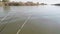 View of three fishing rods over water with nibble hanging from fishing boat.