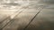 View of three fishing rods over water with nibble hanging from fishing boat. Cloudy sky is on background.