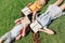 View of three multicultural schoolkids lying on lawn and covering faces with books