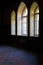 View of three neo-gothic windows with beautiful wooden frames in the interior of a dark room in Sharovsky castle,