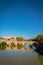 View of the Tiber river in Rome City with bridge crossing the river lined with green trees