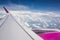 View to Airplane wing and clouds out of porthole window.