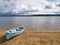View to anchored laminate blue rowing boat at large lake