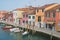 View to the channel, boats and buildings at the street in Murano, Italy.