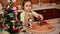 View to a Christmas tree and changing focus on a pretty child girl holding gingerbread cookie cutters at home kitchen