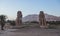 View to the Colossi of Memnon, massive Ancient Egyptian Statues of the Pharaoh Amenhotep III near the ruined Mortuary Temple of Am