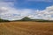 A view to the hill Oblik surrounded by fields and blue sky above near Louny