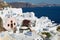 View to hotels buildings with a sea view to volcanic caldera in Oia, Greece.
