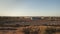 View to a landscape from the window of the moving train at the sunset. Industrial area with warehouse buildings